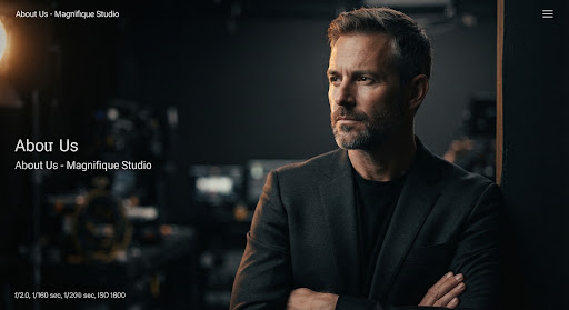 Cinematic, dramatic portrait of a male creative director in a dark studio, lit with a soft luminous amber rim light against deep blacks.